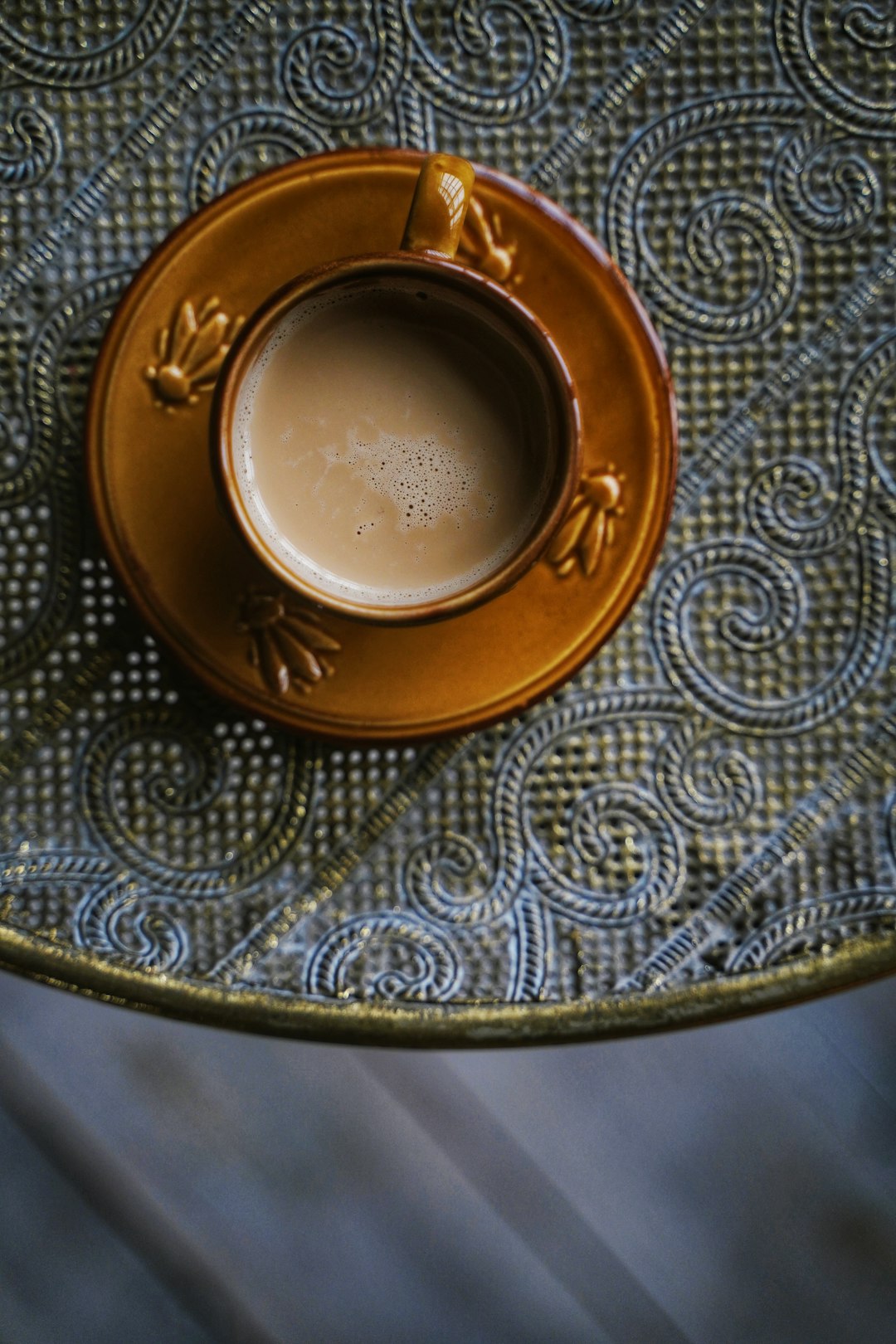 brown ceramic teacup filled with coffee