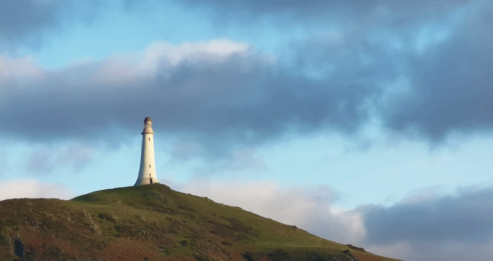 Weißer Leuchtturm auf dem Gipfel des Hügels