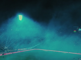 A dark, moody stadium scene illuminated by neon blue and purple track lines, highlighting a 3D-rendered athlete in mid-sprint with dramatic rim lighting.