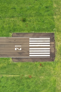 grey pavement on green grass field