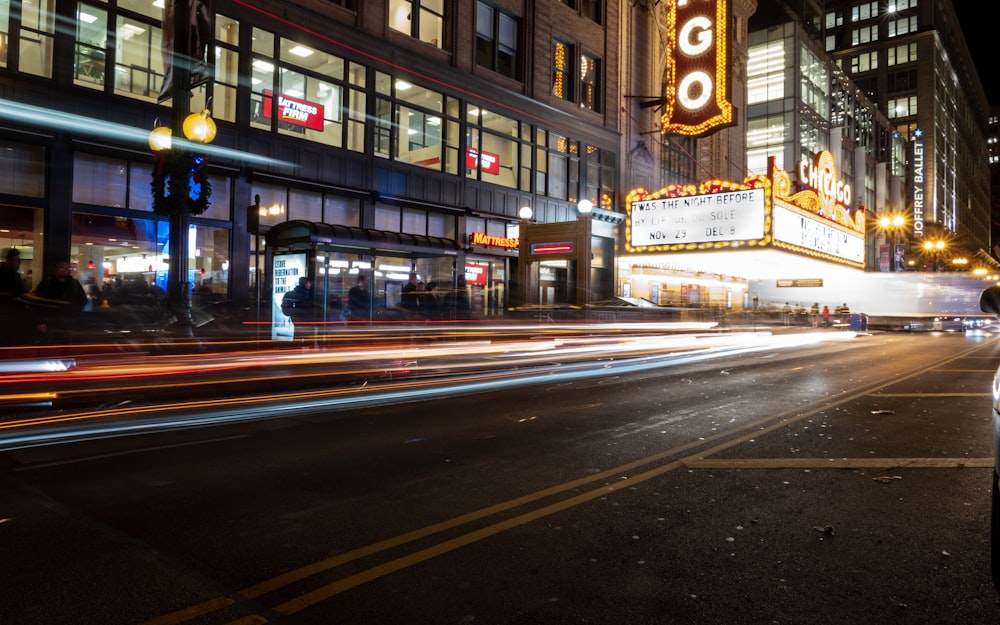 time-lapse photo of road with car passing during night time o ncity