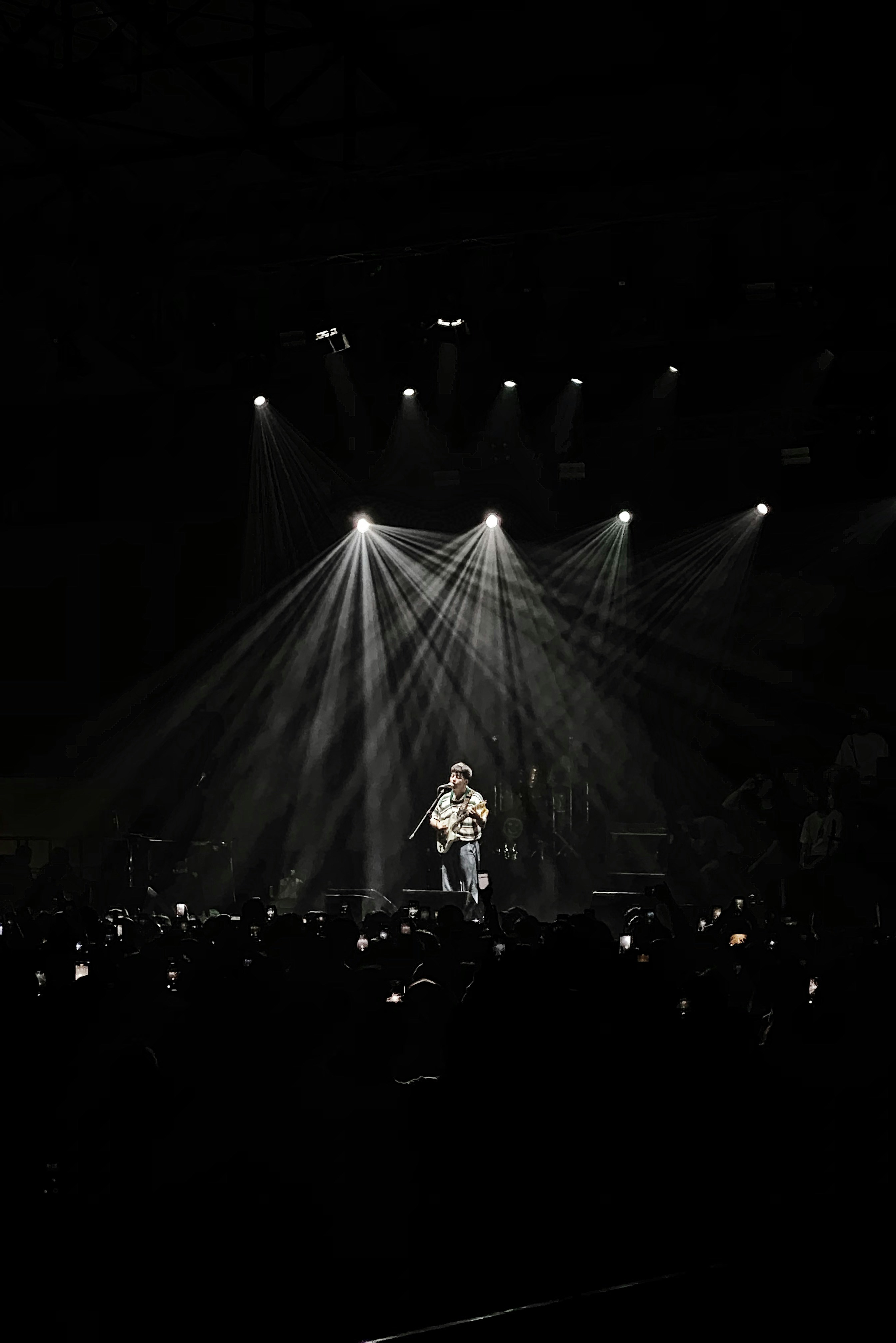 person performing on stage with stage light facing towards him