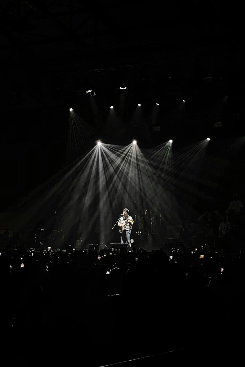 person performing on stage with stage light facing towards him