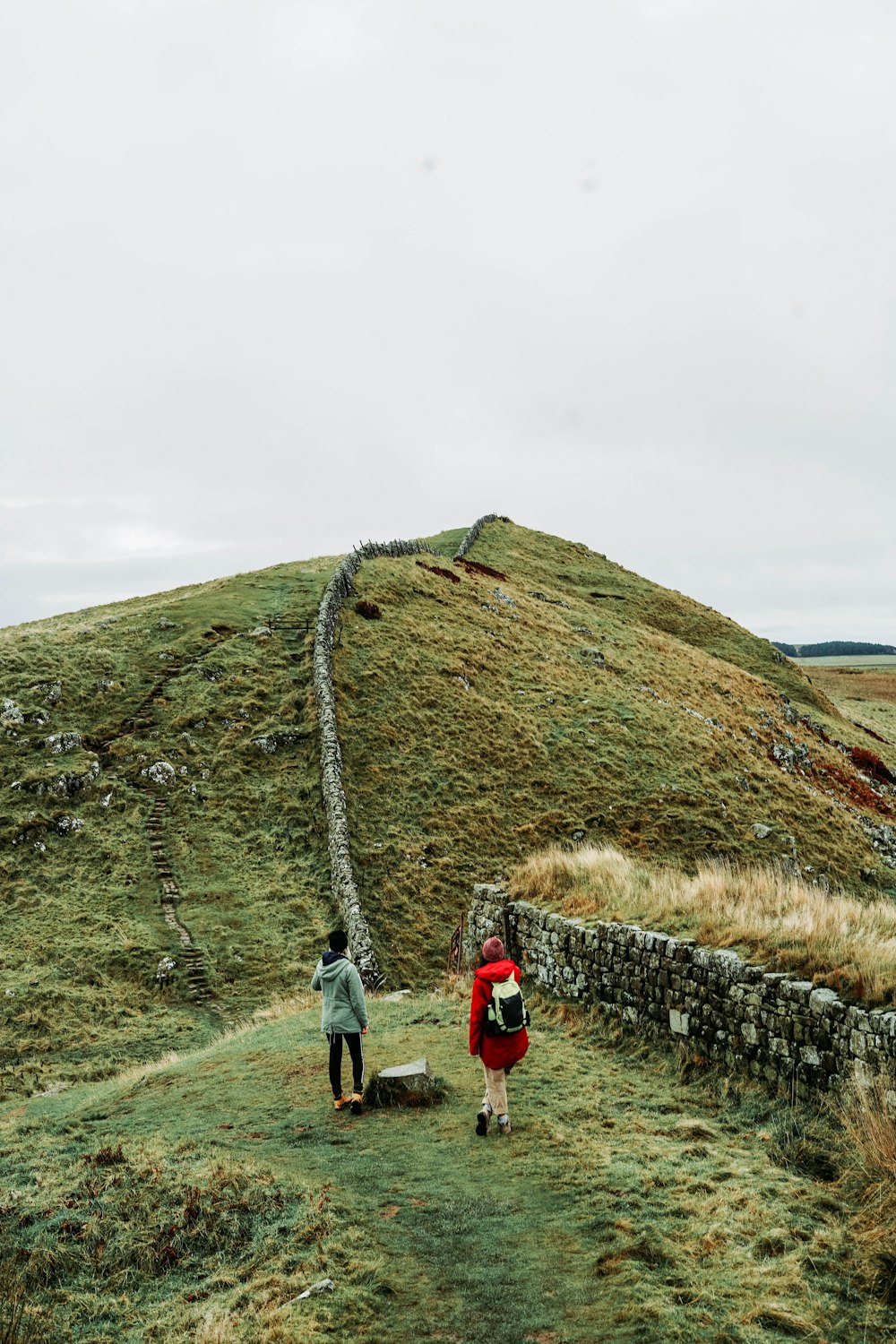 man and woman climbing hill