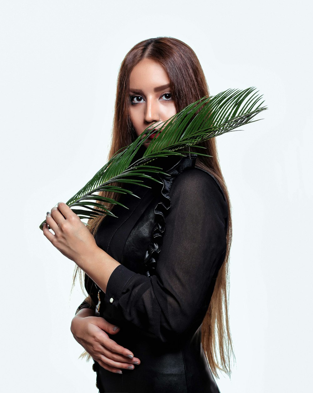 woman wearing black long-sleeved shirt holding leaf