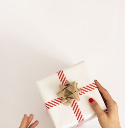 person holding white and red gift box