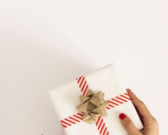 person holding white and red gift box