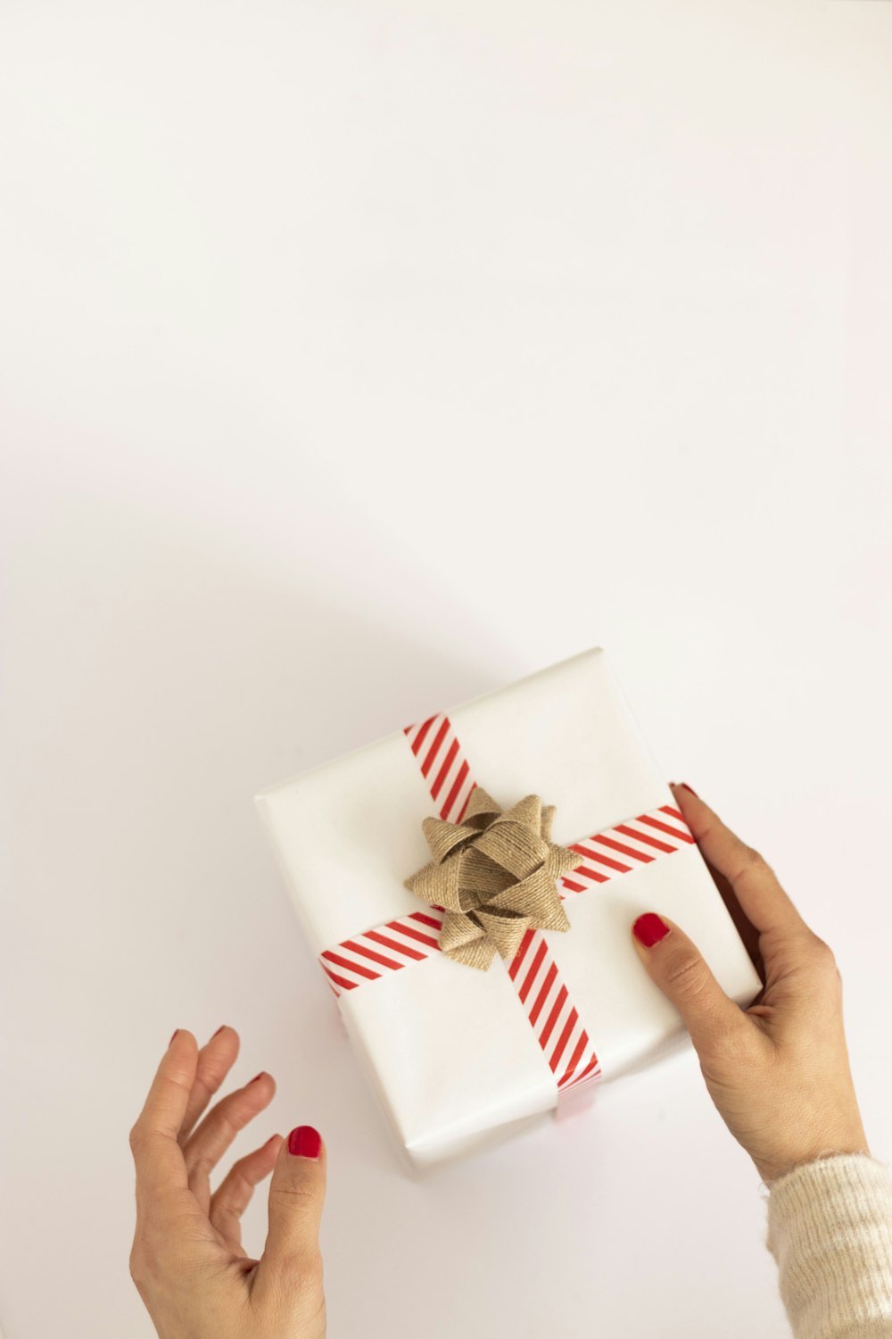 person holding white and red gift box