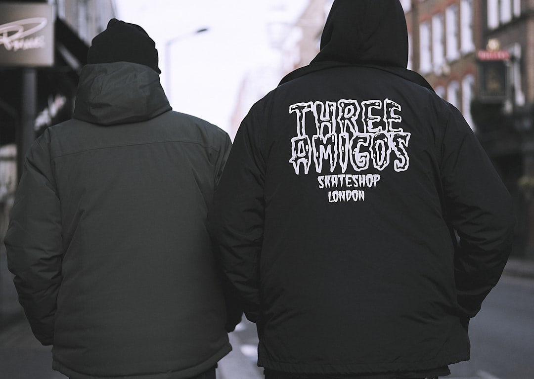 two person wearing hoodies walking on street