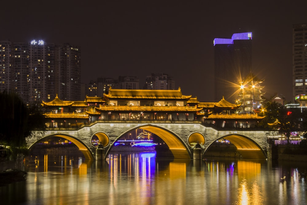 Photographie d’un bâtiment et d’un pont pendant la nuit