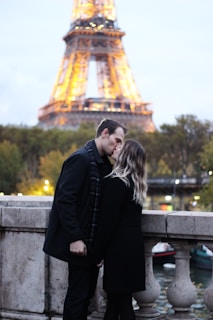 A couple sharing a kiss in front of a famous landmark.