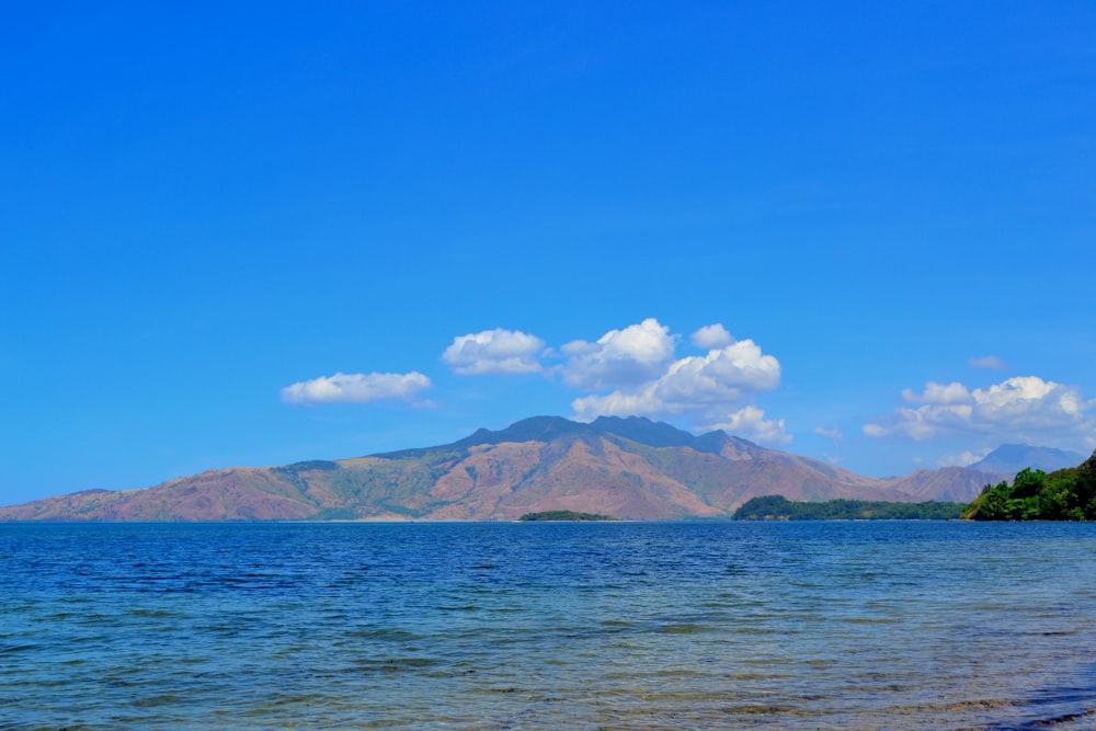 photography of mountain range beside seashore during daytime