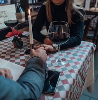 woman wearing black sweater holding hand with man wearing gray suit jacket