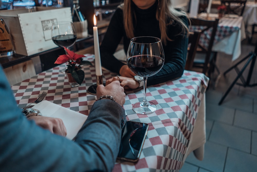 woman wearing black sweater holding hand with man wearing gray suit jacket