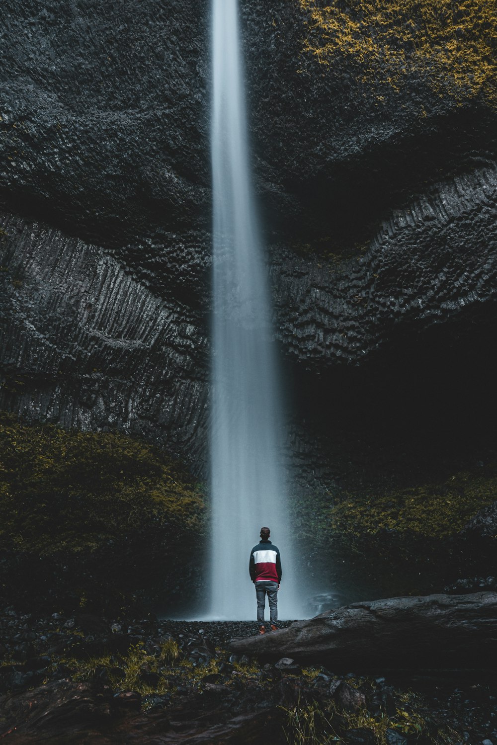 man standing near waterfalls