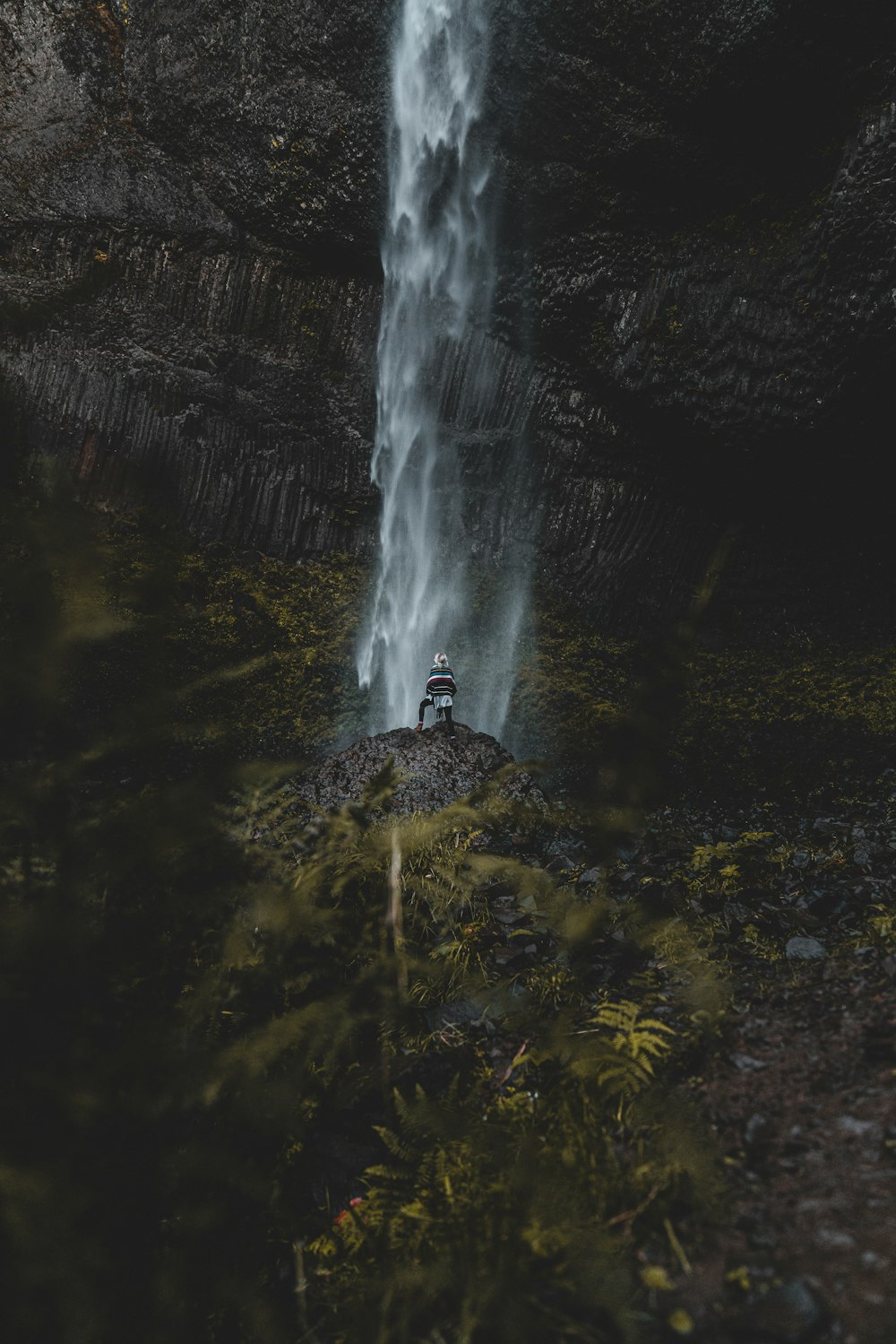 photography of standing person facing on waterfalls during daytime