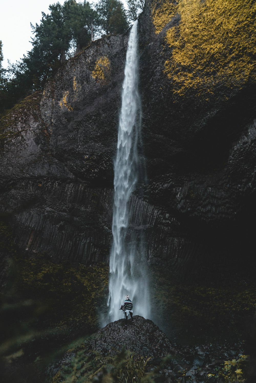 man standing near waterfalls