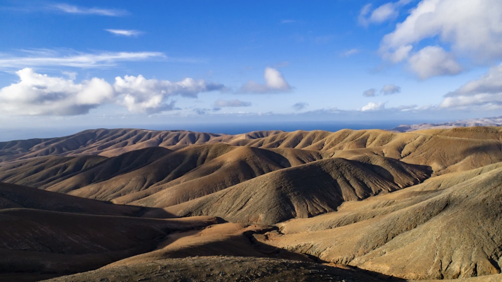 brown hills and white clouds