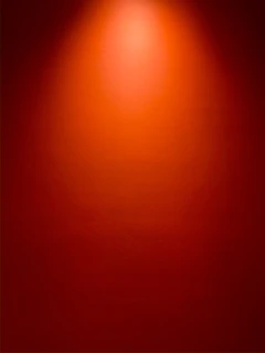 a red wall with a light on top of it