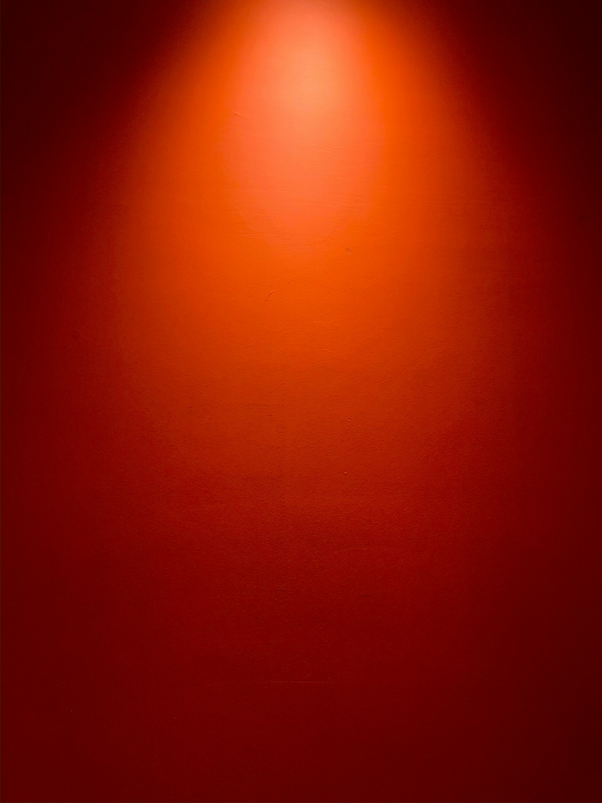a red wall with a light on top of it