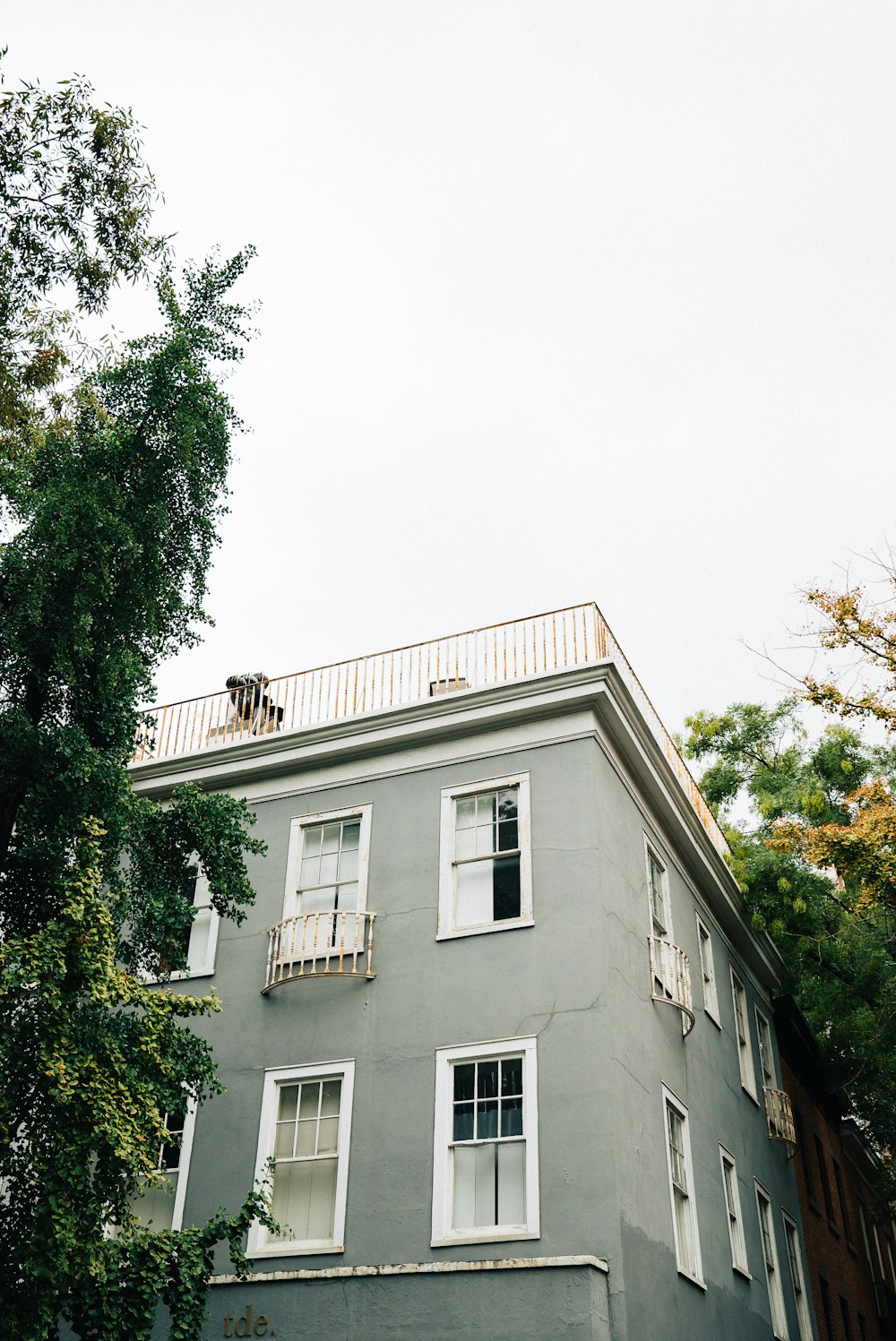 gray and white building with roof deck under white sky