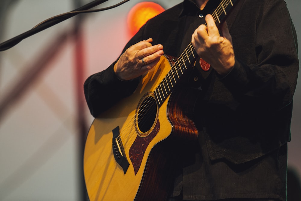 person playing acoustic guitar