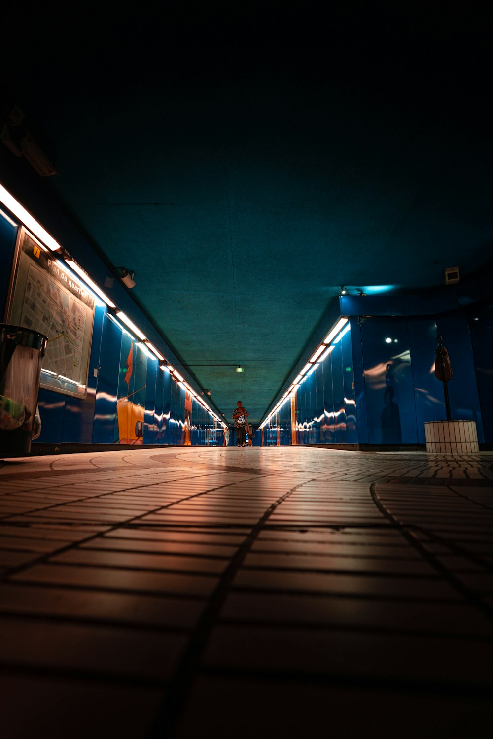 person walking on sidewalk near waiting shed at night