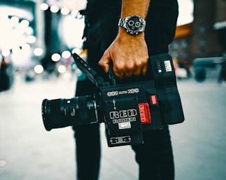 person holding black video camera