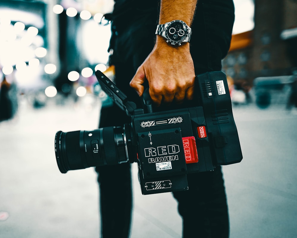 person holding black video camera