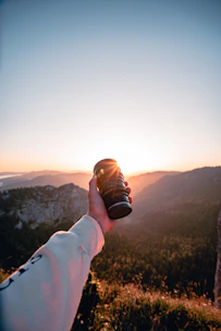 Close-up of a camera lens focused on a mountain landscape at dawn.