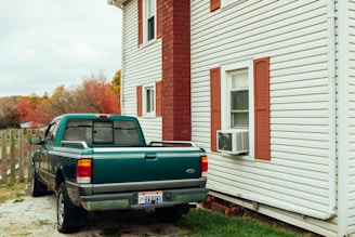 Technician installing a heat pump outside a cozy Quebec home on a crisp autumn day.