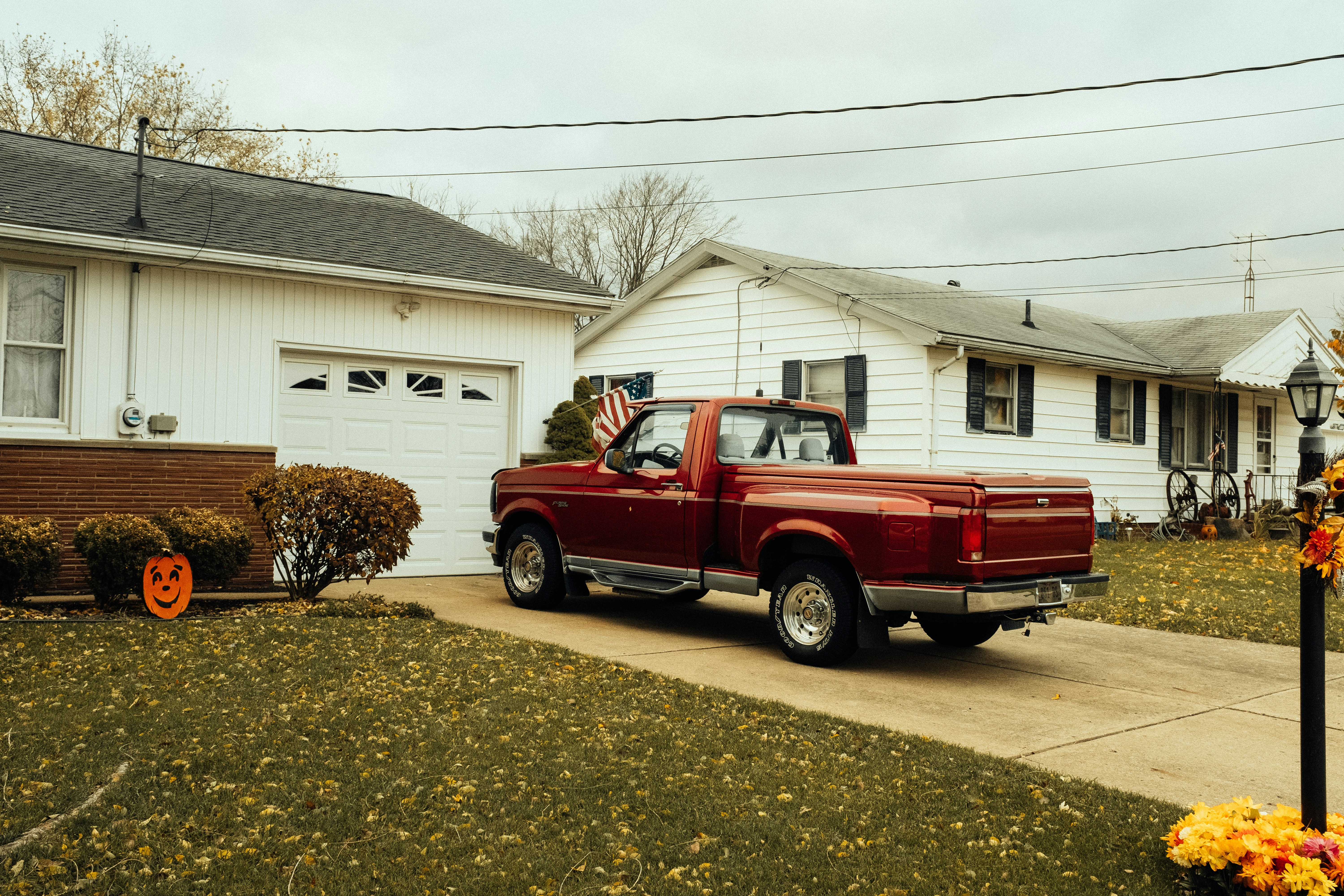 red single-cab pickup truck parking in front of garage during daytime. Your vehicle is also very important when choosing what to do with your driveway