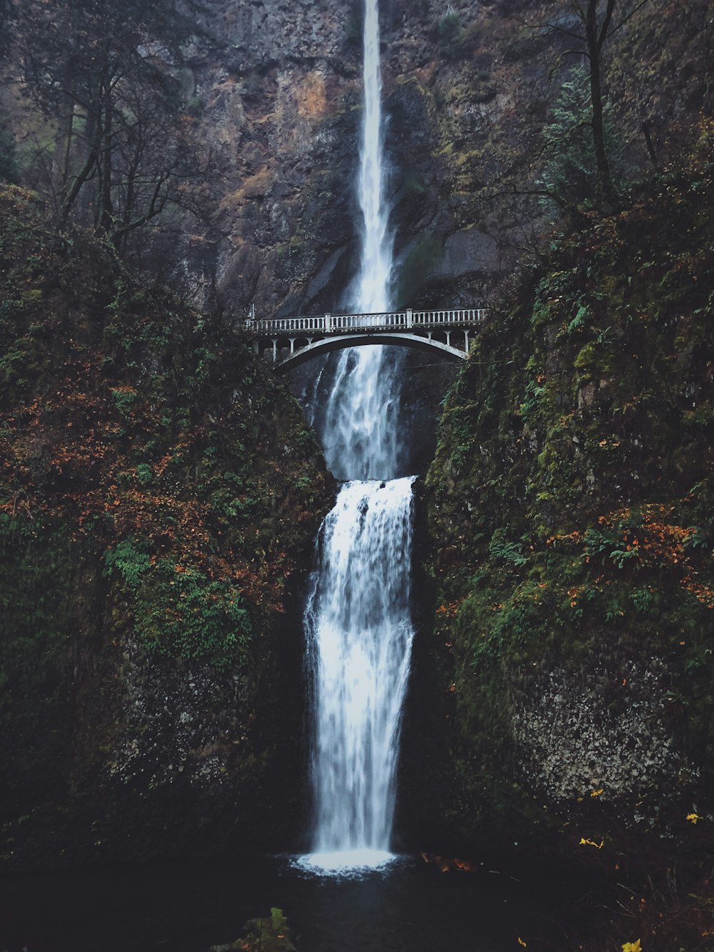 Ponte sulle cascate rocciose della montagna durante il giorno