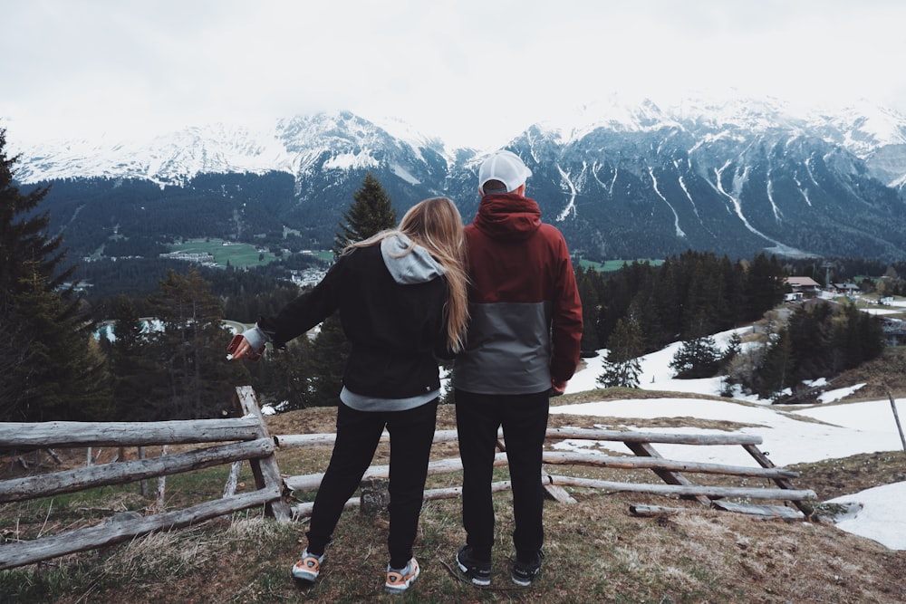 man and woman standing on rock formation