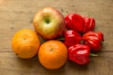 Close-up of ripe, colorful fruits and vegetables arranged on a rustic wooden table.