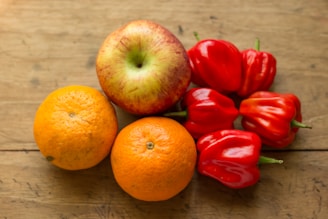 A close-up of fresh fruits and vegetables arranged on a wooden table.
