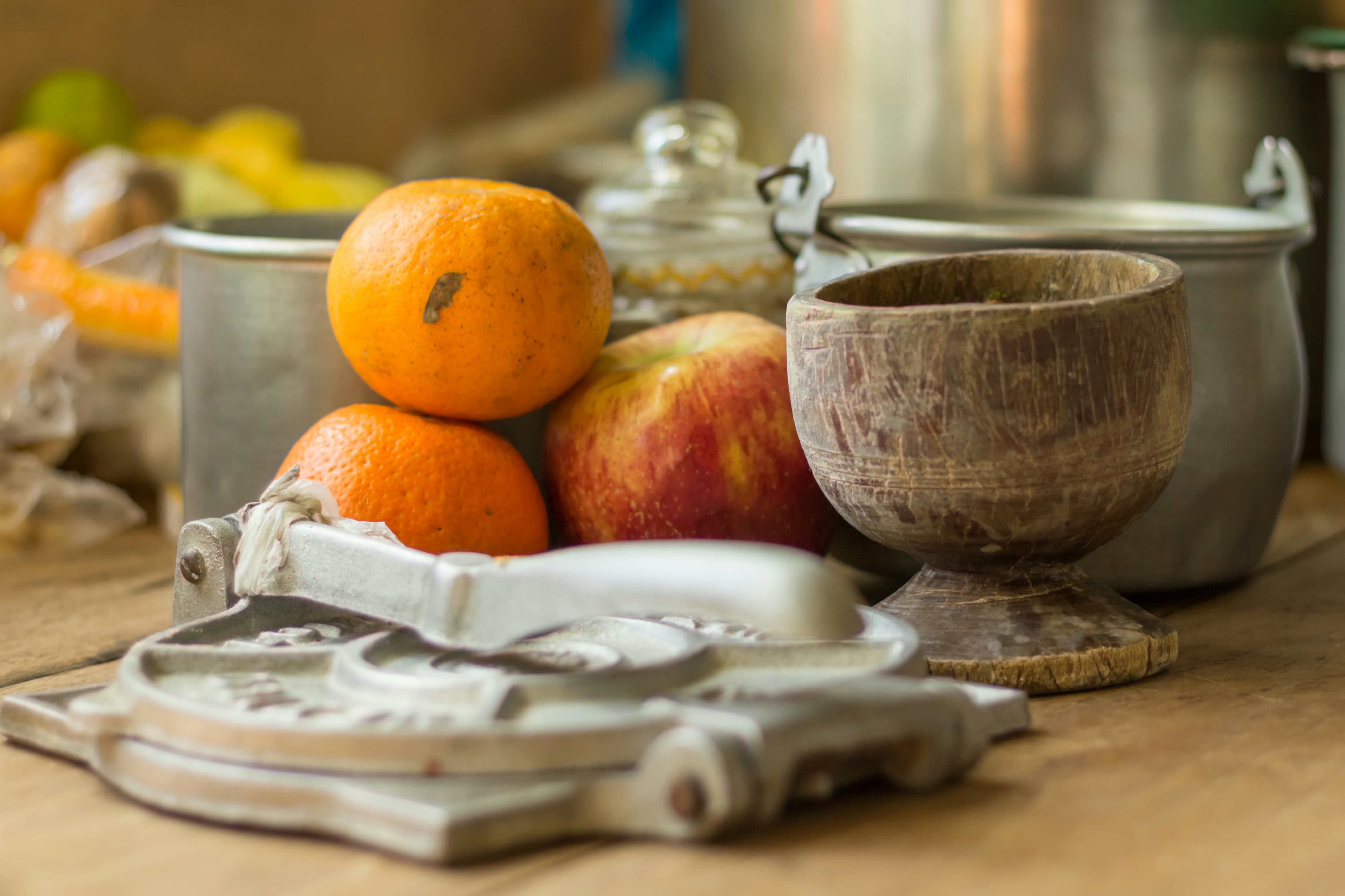 selective focus photography of oranges and apple by pots