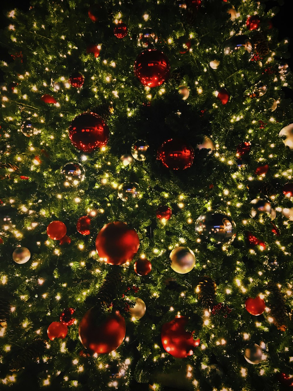 Sehen Sie sich die Fotografie des Weihnachtsbaums mit Kugeln und beleuchteten Lichterketten an