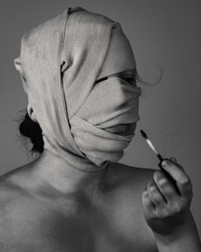 grayscal photo of woman with bandage on face