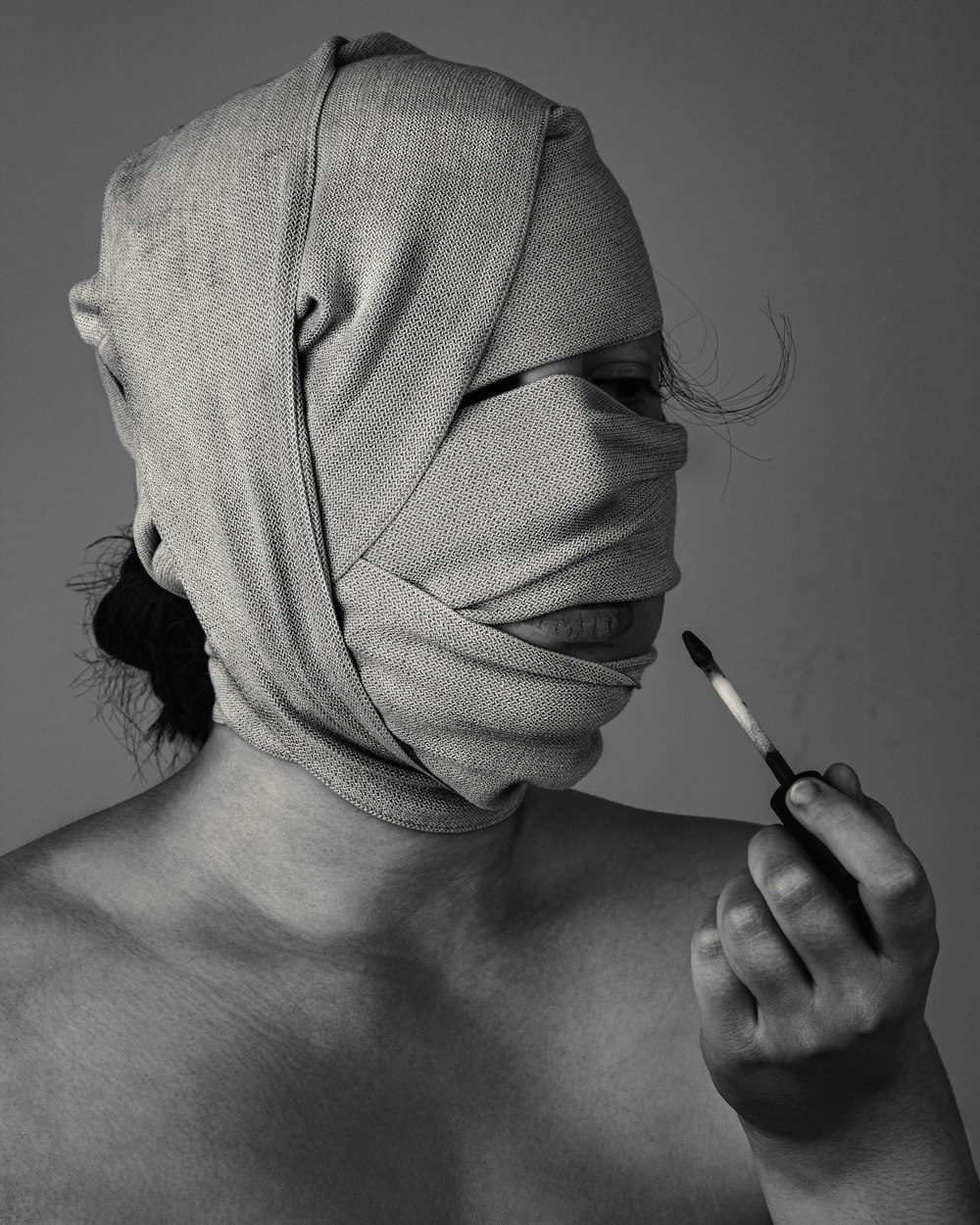 grayscal photo of woman with bandage on face