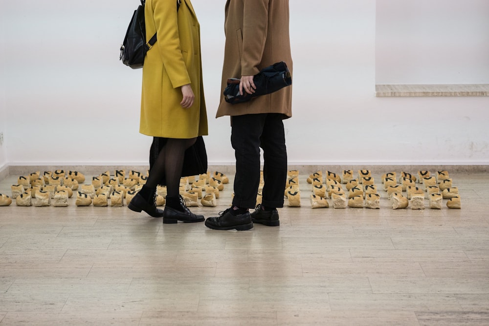 deux personnes portant un trench-coat debout l’une en face de l’autre