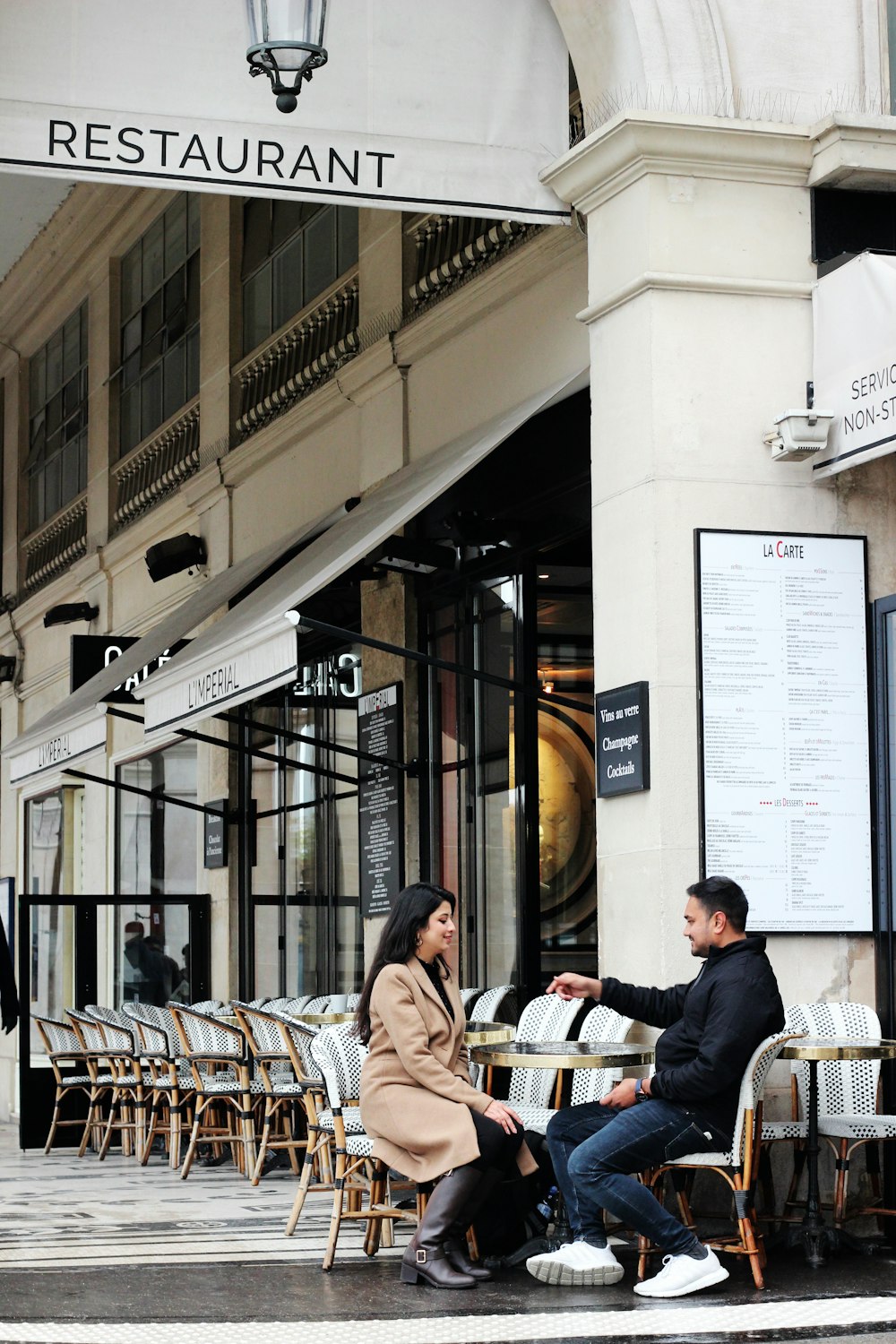 man and woman sitting on chairs beside table