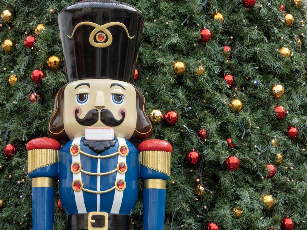 nutcracker beside Christmas tree with baubles