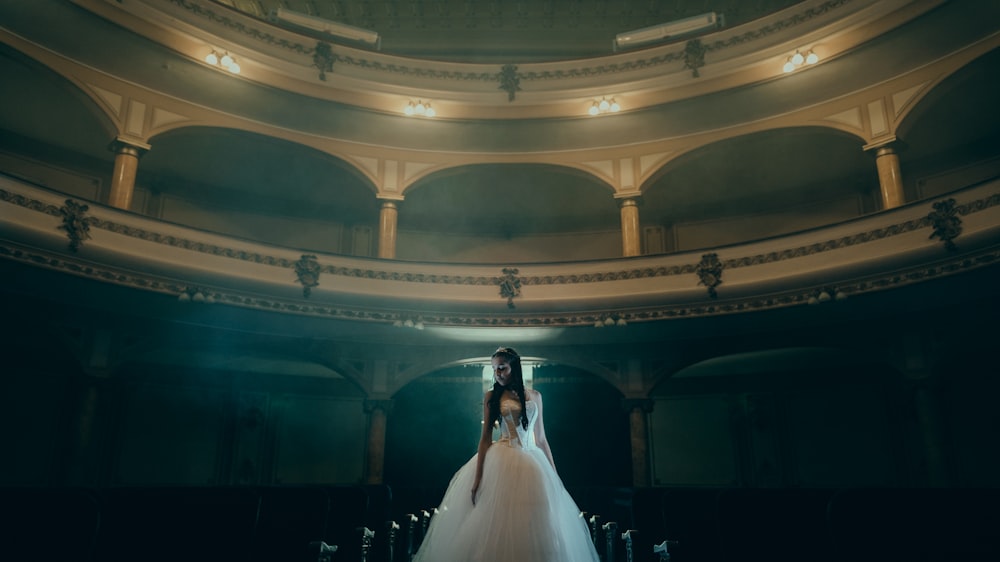 woman in white dress standing inside dome building