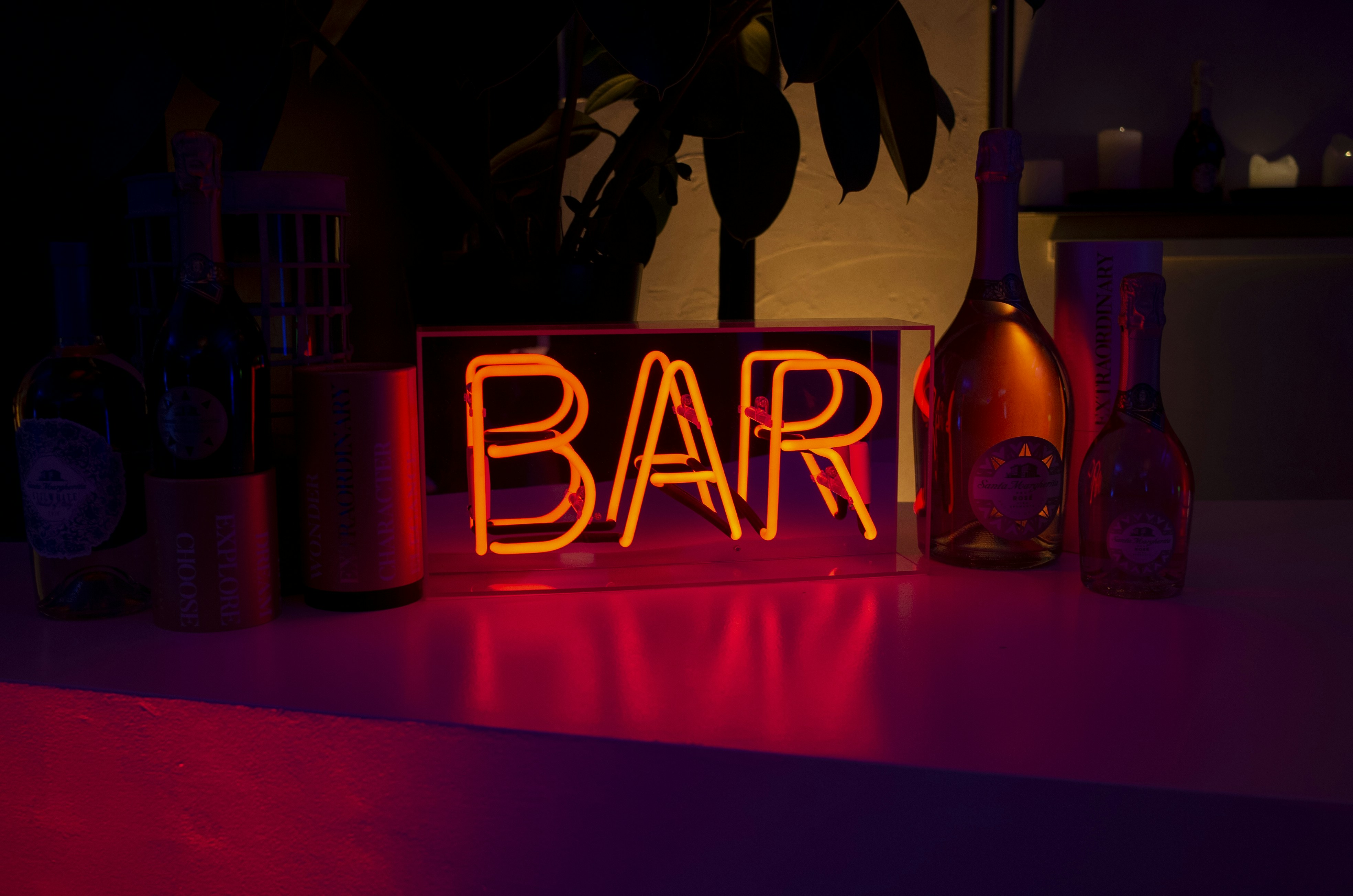 Bar neon sign surrounded with bottles