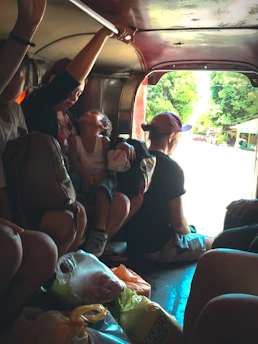 A happy family comfortably seated inside a spacious Nusantara Rent MPV during a trip.