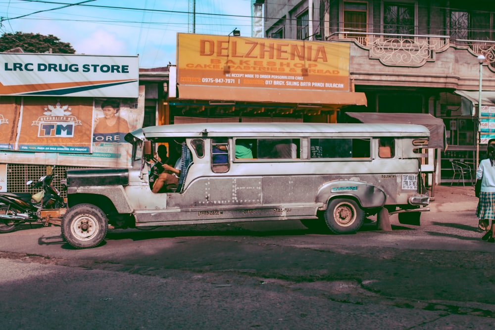 gray jeepney parked in front of house