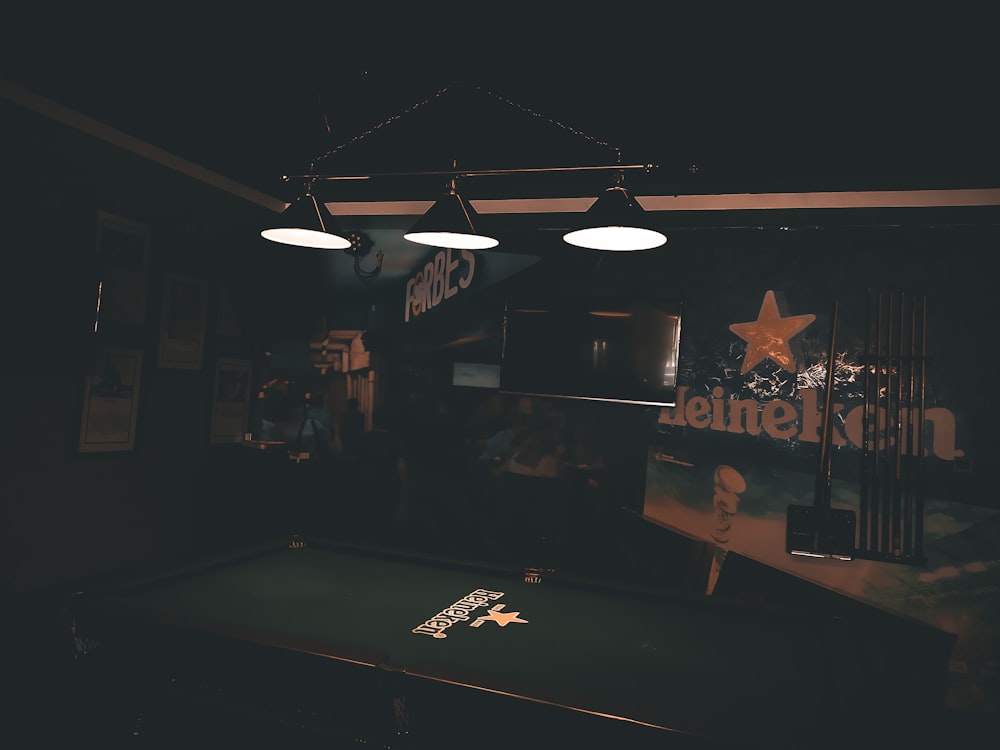 green and brown billiard table with three turned-on pendant lamps