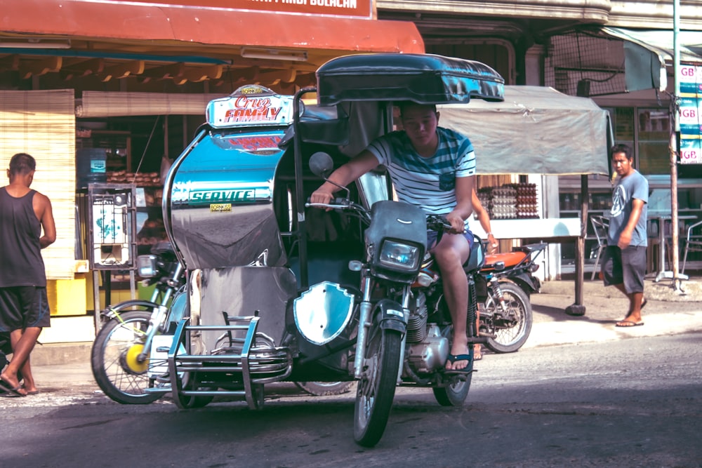 man riding tricycle during daytime