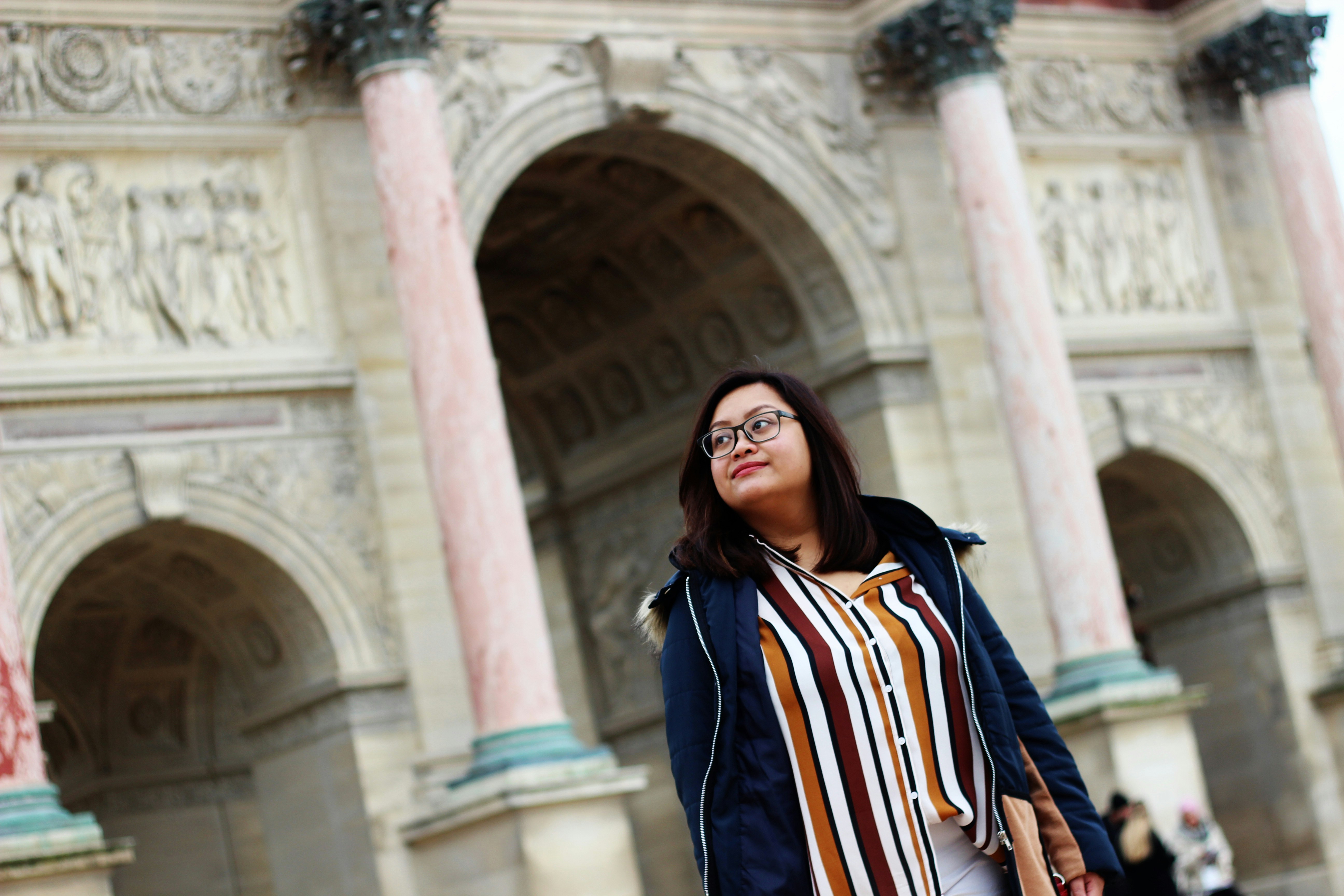 woman in blue parka by arch gateway during daytime